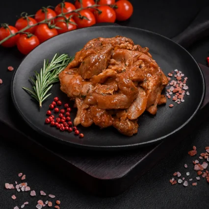 Fajitas mixtas marinadas en salsa BBQ sobre plato negro con romero