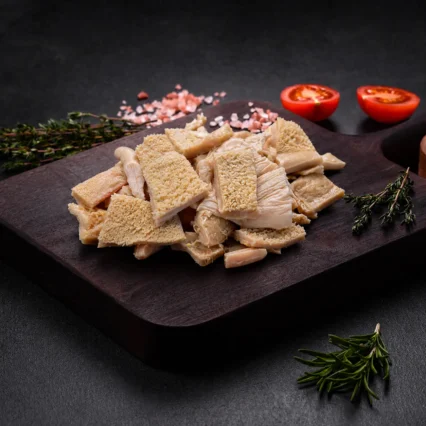 Mondongo cortado en trozos sobre tabla de madera con tomate