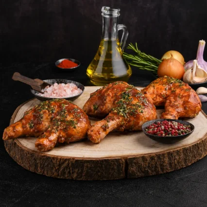 Muslos enteros de pollo marinados en salsa BBQ sobre tabla de madera rústica