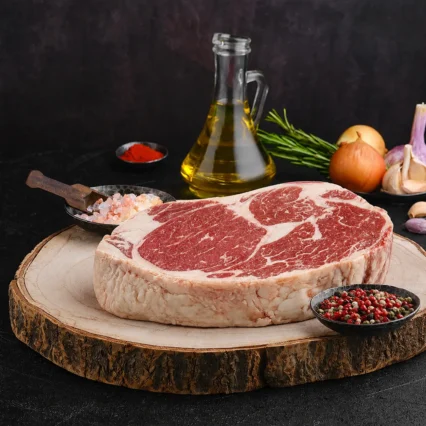 Corte de Rib Eye con marmoleo sobre tabla de madera rústica