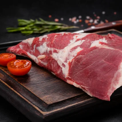 Corte de vacío argentino sobre tabla de madera con tomate cherry